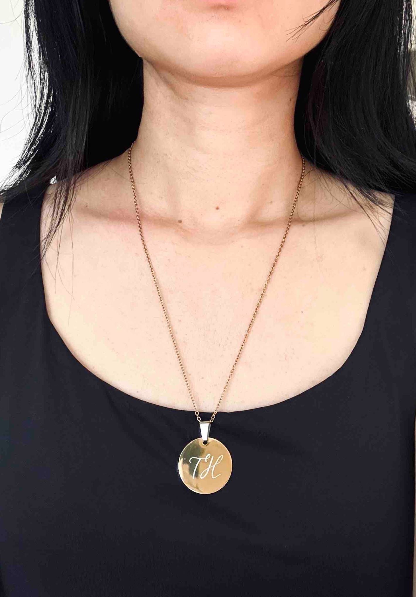 Person wearing a personalised gold necklace with a round pendant